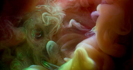 Paint flow. Shiny particles. Defocused pink yellow purple color glitter blend cloud spreading on abstract dark black art background.