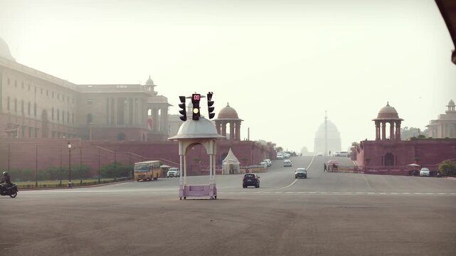 Delhi, India, November 28, 2025. Traffic moving along Kartavya Path with Rashtrapati Bhavan and Secretariat buildings visible during a hazy morning in New Delhi