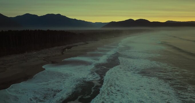 Calm sunset at Maori Beach, Bruce Bay, waves and mountains in view