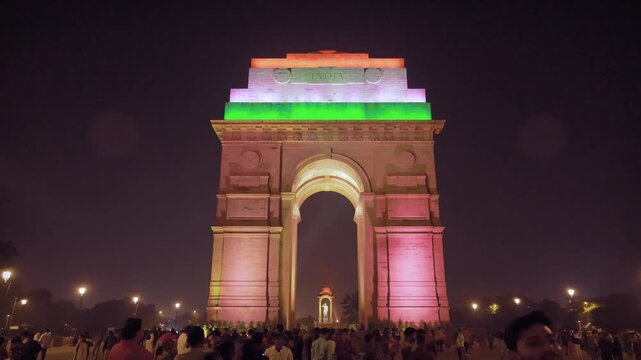 Delhi, India, November 28, 2025. Large public crowd gathers near India Gate as the monument glows in Indian national colors at night