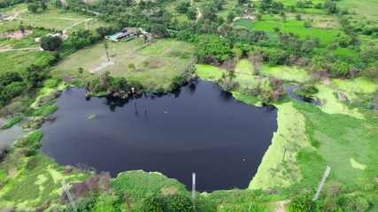 Crop field lands with water pond and current poles. day time, jib shot, drone shot, 4k.