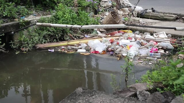 Plastic waste clogs a roadside drain in a city. Footage taken in Java, Indonesia, on December 7, 2025.