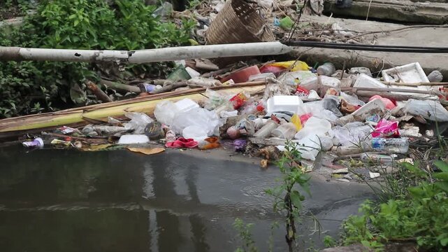 Plastic waste clogs a roadside drain in a city. Footage taken in Java, Indonesia, on December 7, 2025.