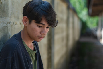 A quiet moment of reflection as a young boy stands by the wall, lost in thought, capturing the tenderness of growing emotions and unspoken stories.