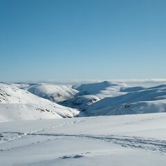 Wide angle view of snow covered rolling hills under a clear blue sky winter landscape