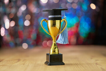 small mortarboard restng on trophy