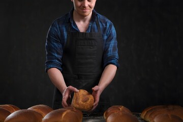 Baker Holding Freshly Baked Loaf of Bread in Bakery