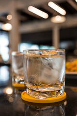 Refreshing glass of water with ice cubes in restaurant