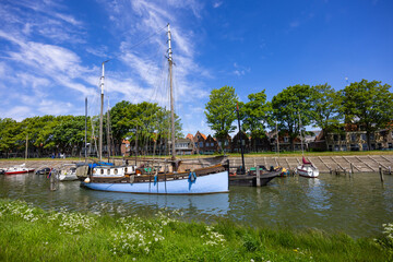 Traditional blue fishing sail boat in a river near hoorn, Netherlands.