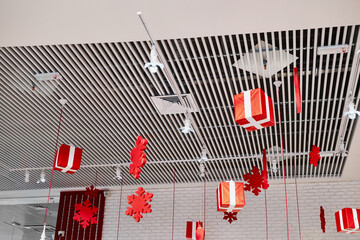 Christmas decorations featuring red gift boxes and snowflake ornaments hanging from modern white...
