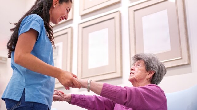 Young woman helping senior citizen in a nursing home