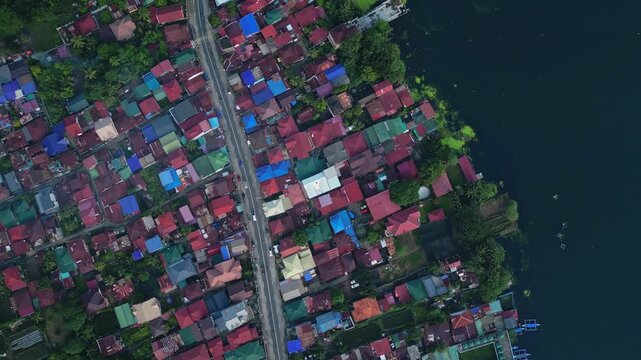 A top-view aerial of the main Talisay town with colorful rooftops lining the lakeside edge of Taal Lake in Batangas, Philippines