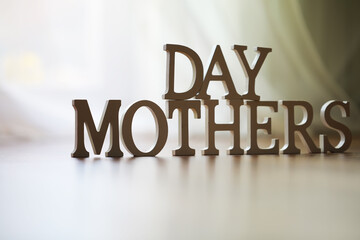 Mother's Day Message with Wooden Letters on Bright Background Celebrating Motherhood