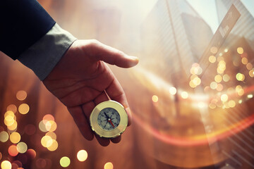Double exposure businessman with vintage compass in a hand and skyscraper. concept to make decision or choose direction