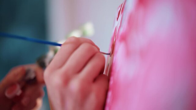 CloseUp Hands Painting Pink Canvas With Small Brush, Freelance Artist Adding Delicate Petals And Fine Outlining On Floral Artwork In Bright Home Studio Soft Bokeh Background And Steady Wrist