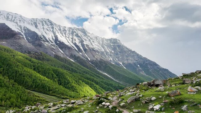 4K Landscape shot of clouds above the snowy Himalayan mountain peaks as seen from Sural Bhatori in Pangi Valley, Chamba district, Himachal Pradesh, India. Scenic view of snowy Himalayan mountains.