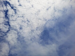 White cotton-like clouds floating over a soft blue sky creating a calm and airy view, blue sky with clouds