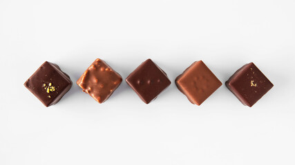 Assortment of chocolates lined up on a white background