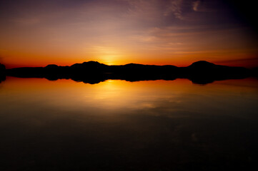 夜明けの湖の劇的な日の出の場面。水面に反射する空。