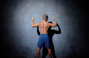 Obraz premium ポーズをとる筋肉のあるシニアの男性 後ろ姿