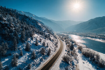Fototapeta premium Panoramic aerial view of a snowy winter landscape with a road and a river