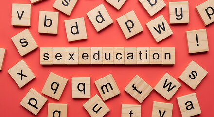 Wooden letter tiles spelling 'sex education' surrounded by scattered alphabet tiles on red letters
