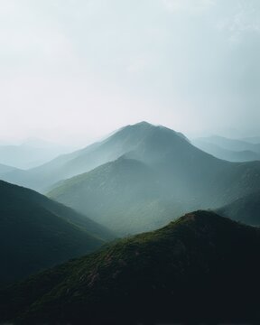 Dreamy layered mountain landscape fading into soft mist with atmospheric light for tranquil nature and scenic backgrounds