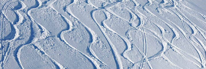 Ski  and snowboard tracks in powder snow, winter sports background.