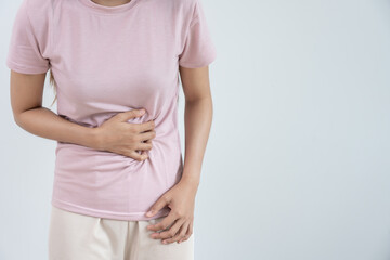 Asian women have stomach ache. Stomach ache due to eating irregularly, menstrual cramps,...