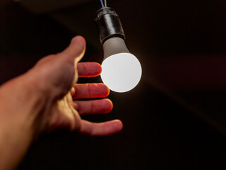 hand replacing electric bulb