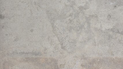 Gray concrete sidewalk with stains and uneven color. Roadside walkway. Texture and background image.