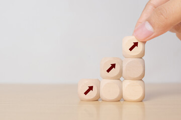 Business performance growth concept. Wooden cube stairs with increasing arrow icons on grey background. Goals, vision, plan, action for business development. Growth,high performance banner