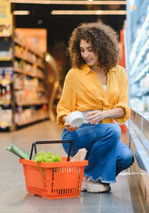 Woman shopping for groceries in supermarket aisle