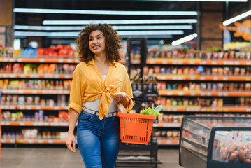 Woman shopping for groceries in supermarket aisle