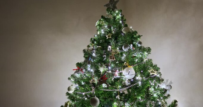 Decorated Christmas tree with silver baubles, wooden reindeer ornaments with red ribbons, ballerina and mouse toys, glowing fairy lights and bead garlands. Christmas tree decorations