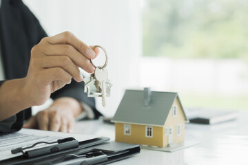 Real estate agent handing property keys to customer.