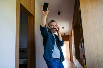 Bearded man dancing at home while listening to music.