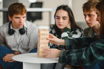 Friends playing stacking tower wooden block game