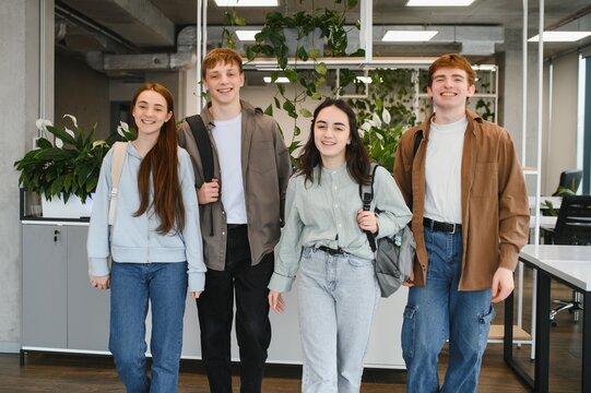 Happy students walking together in university hallway - Powered by Adobe