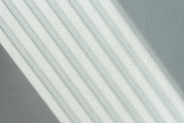 Light and shadow from the window shutters on the concrete wall background