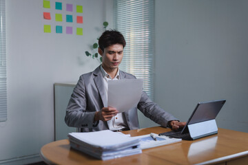 Businessman reading document feeling puzzled in office