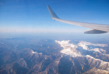Fototapeta premium Caucasus mountains with snow peaks in aerial winter scene. Aerial view from plane.