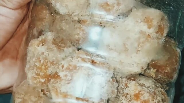 close up view of fresh jaggery pieces inside clear jar