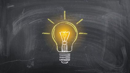 Innovation and inspiration for students represented by a glowing lightbulb on a school chalkboard