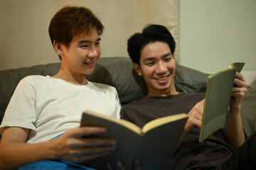 A cheerful moment of a couple reading together in bed, surrounded by soft lighting and a calm, comfortable setting