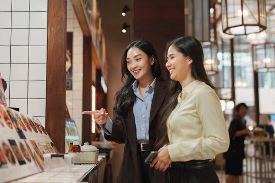Two young women ordering food at restaurant counter