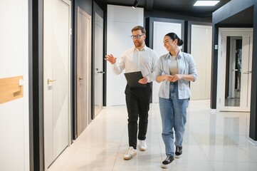 Shop assistant showing doors to customer in hardware store