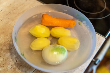Fresh vegetables in water prepare for cooking in a kitchen setting