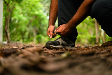 Person tying shoelace before hiking in nature