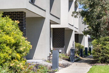 Modern townhouse building exterior and walkway in a suburban residential neighborhood in Tarneit, Melbourne, Australia. Concept of contemporary housing design, urban living,residential architecture